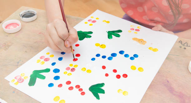 istock The girl paints on paper with her hand 934818268