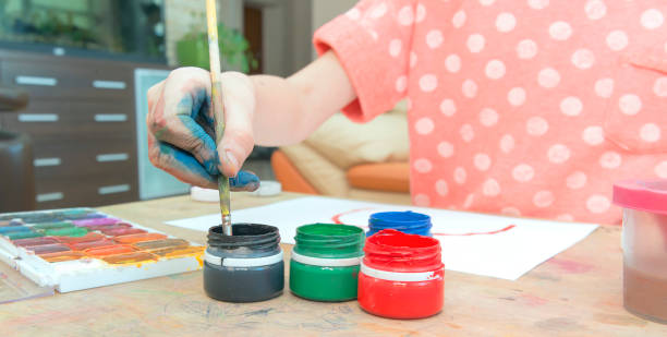 istock The girl paints on paper with her hand 934818402