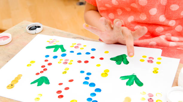 istock The girl paints on paper with her hand 934818406