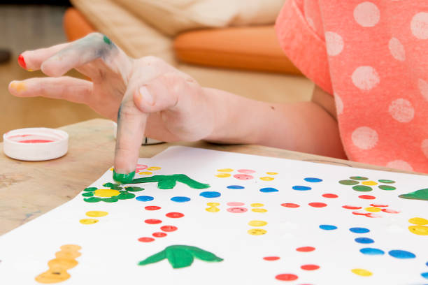 istock The girl paints on paper with her hand 934818410