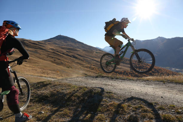 istock Mountain biker watches other biker ride down trail. 934819778