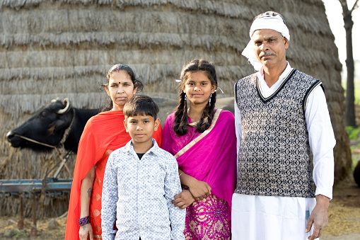 Rural Indian family posing in front of buffalo