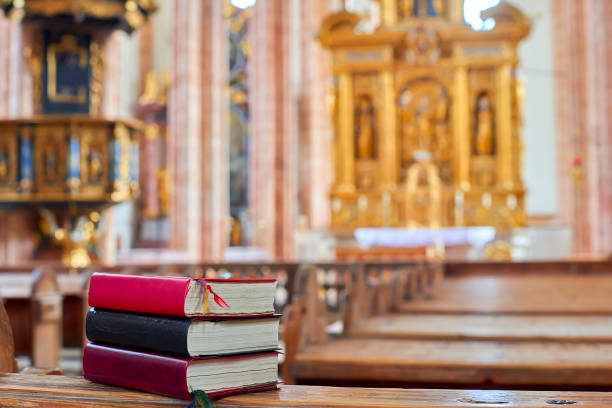 A stack of old church books rests on the altar, with the ancient Scandinavian church visible in the background