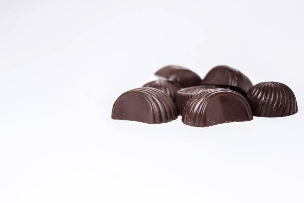 caramelle al cioccolato su sfondo bianco - peanut bowl nut circle foto e immagini stock