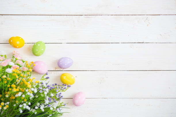 istock Easter eggs with flowers on white wooden background 934826184