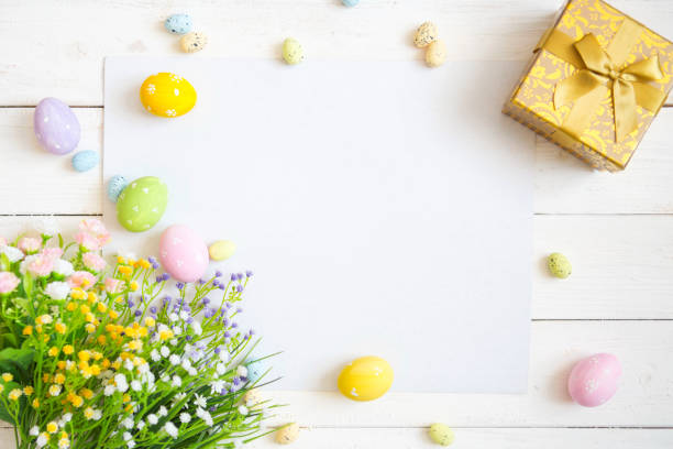 istock Blank sheet with easter decorations on the white wooden background. Easter greeting card 934826236