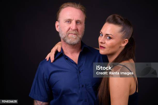 Portrait Of Couple Against Black Background Stock Photo - Download Image Now - 40-49 Years, Adult, Adults Only