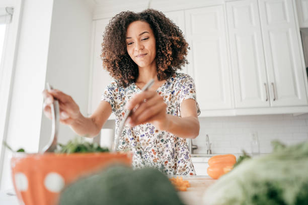 istock Woman mixing a salad in the kitchen 934828358
