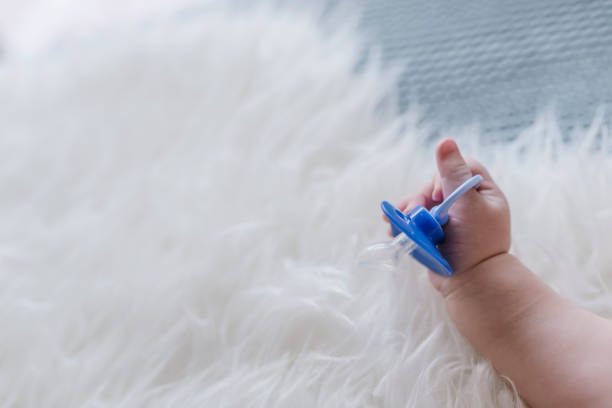 istock Close up of baby hands with pacifier 934842658