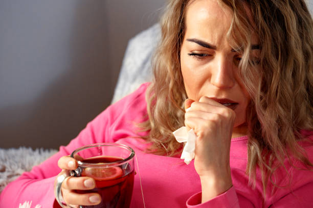 istock sick woman drink tea and lying in bed at home 934842856
