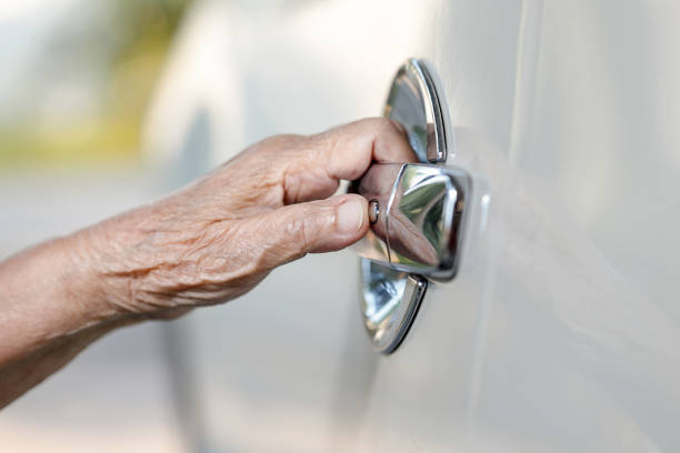 istock elderly woman hand opening car door 934843308