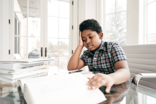 istock 8 years old boy doing homework in a domestic kitchen 934843610