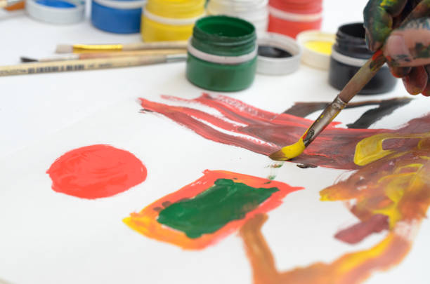 istock A child's hand in paint paints gouache on white paper. 934846598