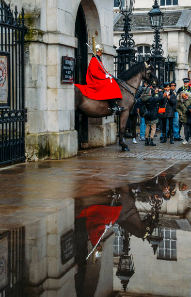 horse guard outside the household cavalry division in whitehall surrounded by tourists on a cold day - tourist photographing armed forces military imagens e fotografias de stock