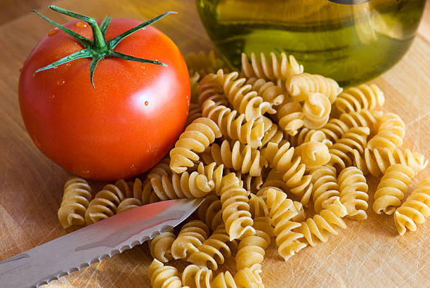 olive oil, pasta, and a fresh tomato stock photo
