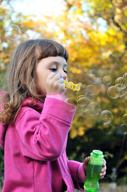 istock little girl blowing soap bubbles 93486164
