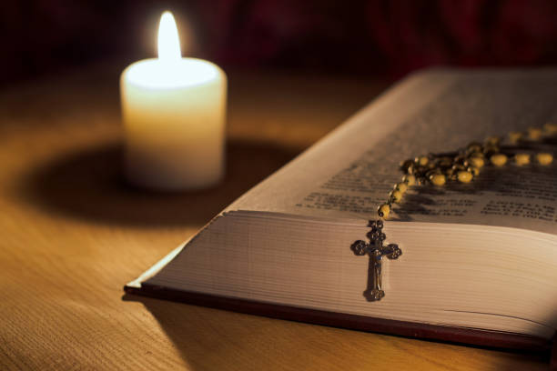 płonąca świeca, biblia i krzyż różaniec na drewnianym stole - rosary beads bible prayer beads catholicism zdjęcia i obrazy z banku zdjęć