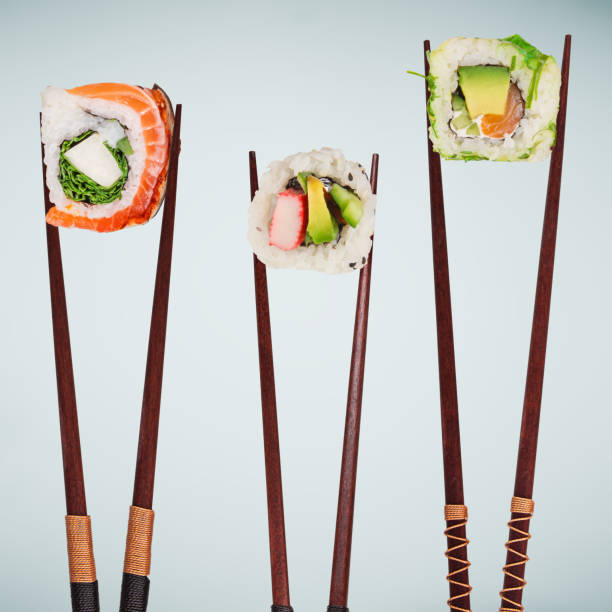 istock Traditional japanese sushi pieces placed between chopsticks on pastel color background 934866298