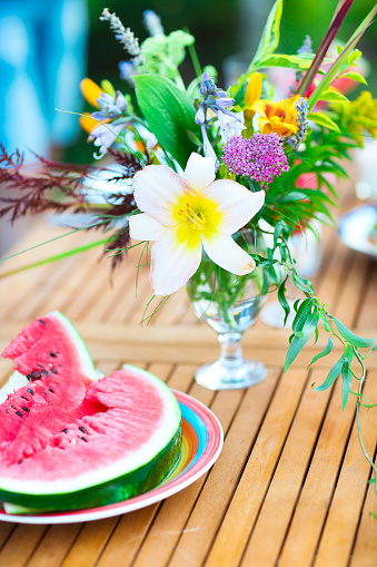 Summer outdoor party with watermellon and lemonade, decorated with flowers