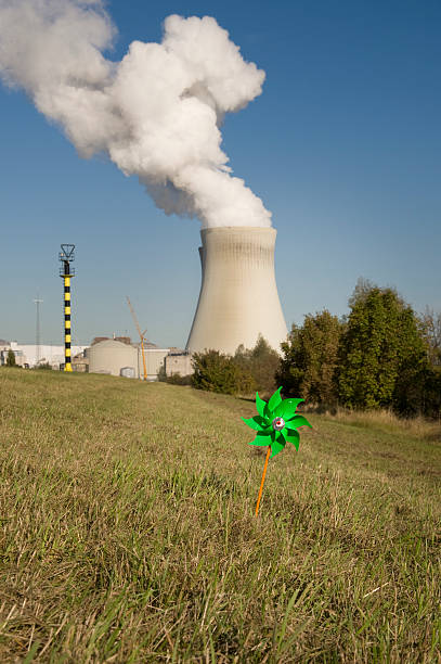 rispetto a vento di energia nucleare - wind power toy symbol cooling tower foto e immagini stock