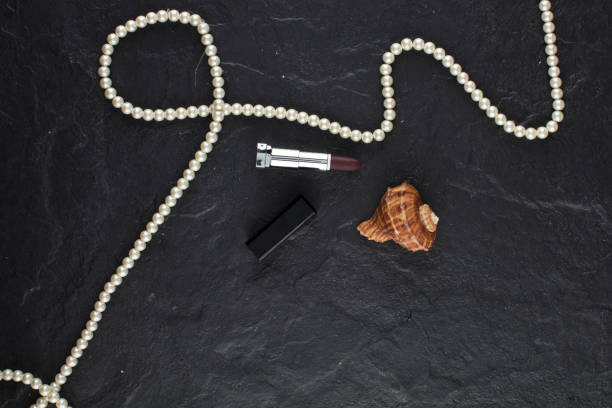 istock Beauty products, lipstick,seashell and pearl necklace 934870104