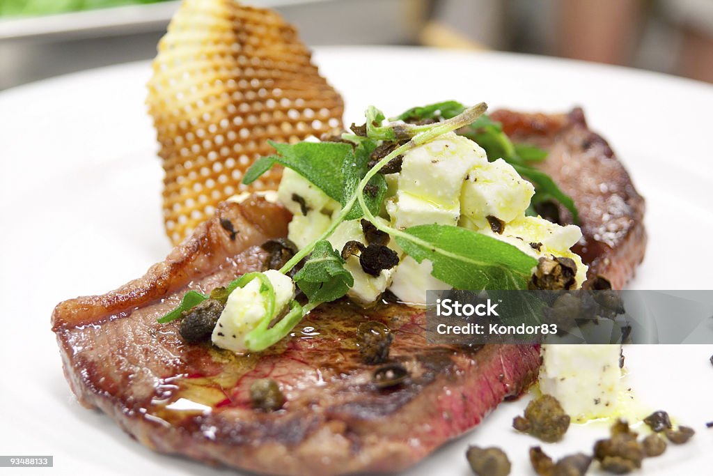 Rari preparati Bistecca di manzo con capperi e topping al formaggio - Foto stock royalty-free di Al sangue