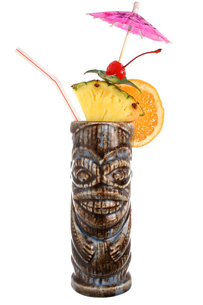 A tropical cocktail in a cup resembling a carved statue Tropical cocktail served in a tiki mug and garnished with fruits. fruit garnish stock pictures, royalty-free photos & images