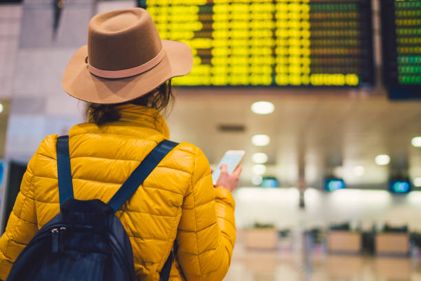 dziewczyna na lotnisku sprawdzająca tablicę wylotu - heathrow airport london england airport station zdjęcia i obrazy z banku zdjęć