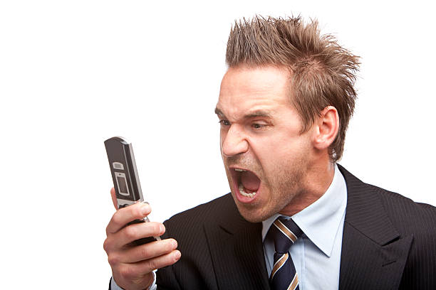 A stressed, young businessman screaming into phone stock photo