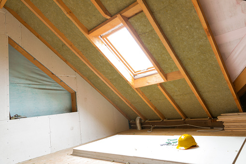 House attic under construction mansard wall insulation with rock wool