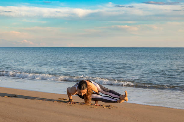 istock Beautiful woman doing yoga on the beach 934906854