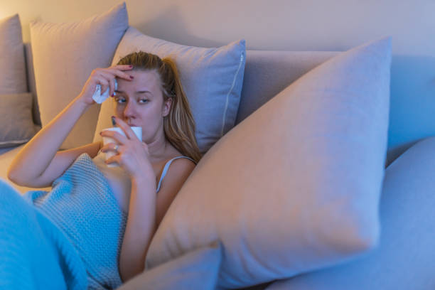 istock Young girl sick in bed with temperature drinks hot 934912208