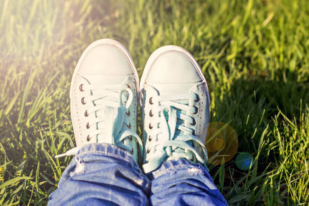 istock Female legs in a clearing with green grass. 934918894