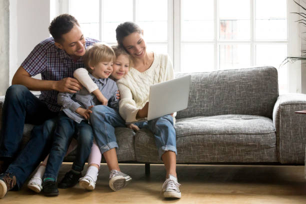 familia feliz con niños pequeños disfrutar usando el ordenador portátil a - internet lifestyles wireless technology relaxation fotografías e imágenes de stock
