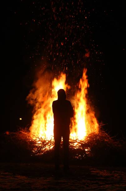 istock Silhouette of man by the fire at night. 934922848