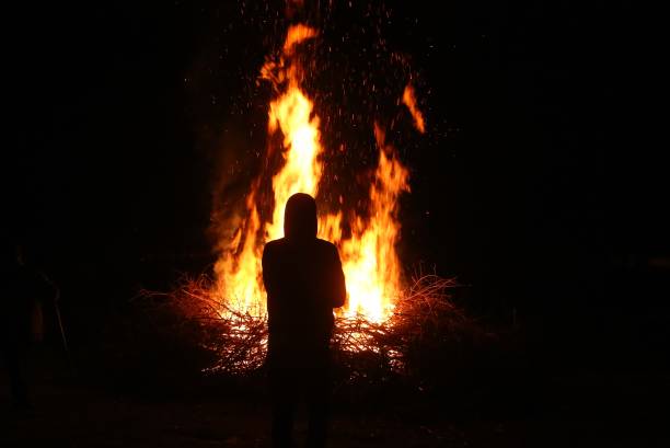 istock Silhouette of man by the fire at night. 934922974