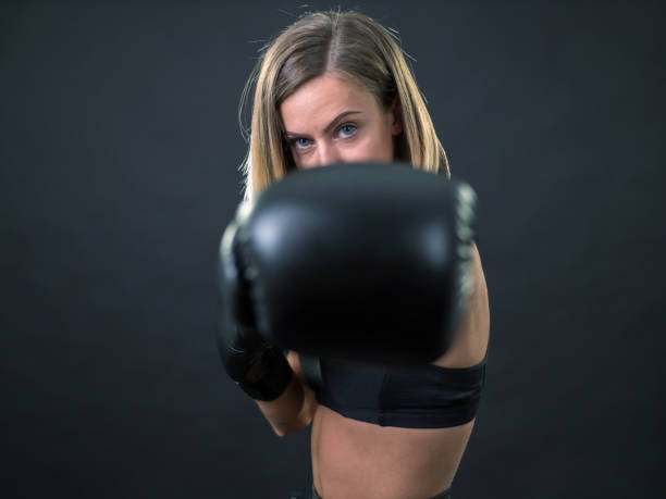 istock Female blond boxer fighter with boxing gloves looking at camera 934933546