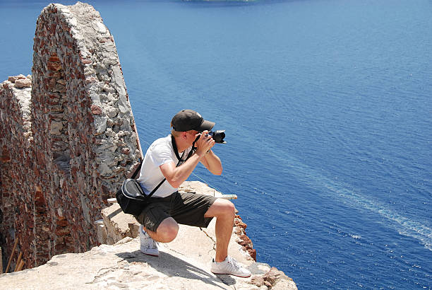 istock young photographer taking picture on rooftop in Santorini 93494726