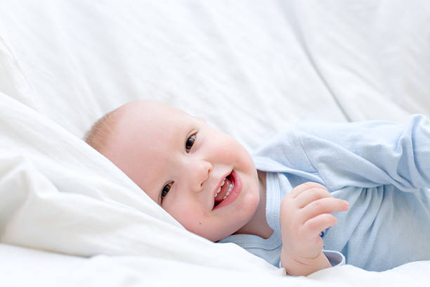 istock Little joyful baby resting on white bed. 93495625