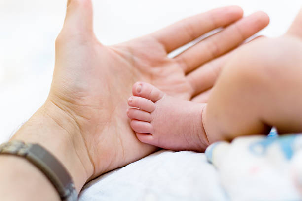 istock Father hold baby leg in hand 93496302