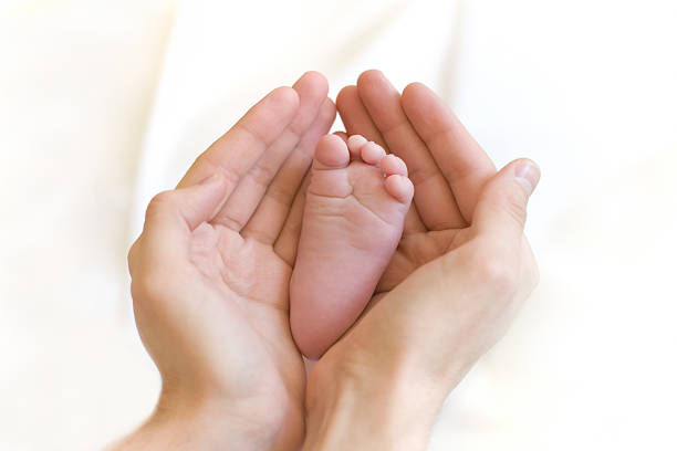 istock Father gently hold baby's leg in hands 93497675