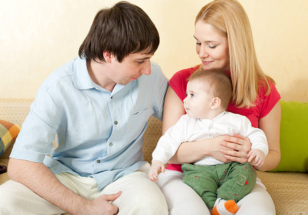 istock Young happy family sitting on sofa at home 93497995