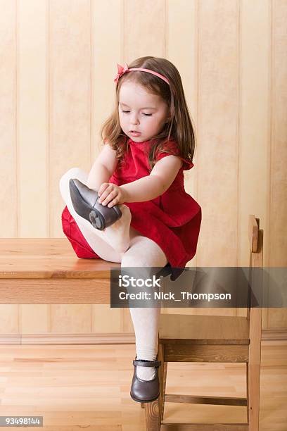Kleines Mädchen Sitzt Am Tisch Auf Einem Schuh Stockfoto und mehr Bilder von Anziehen - Anziehen, Schuhwerk, Baby