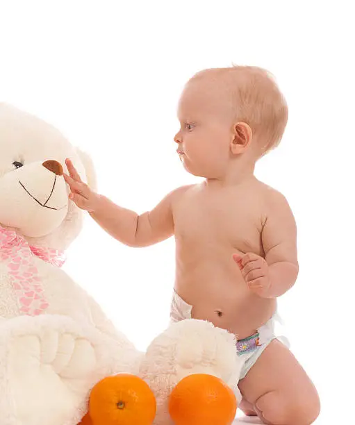 Photo of Portrait of baby boy bring two oranges to favorite bear