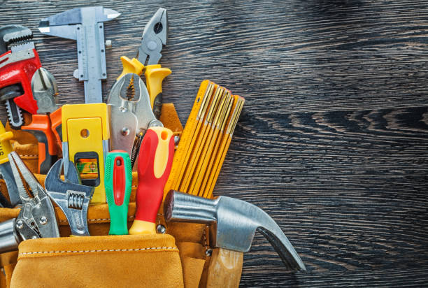 istock Leather tool belt building tooling on wooden board directly abov 935008114