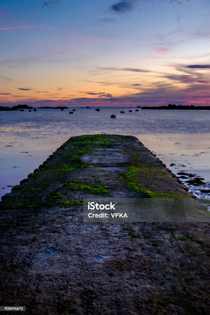 Sunset at Cobo Bay, landing stage, pier, made of concrete, Grandes Rocques, Guernsey, Channel Islands Bay of Water Stock Photo