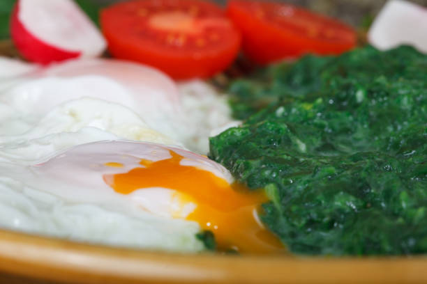 Fried eggs with soft yolk and creamy spinach