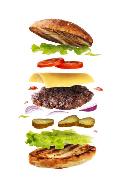 вкусный гамбургер с летающими ингредиентами, изолированными на белом фоне. свежесваренный бургер крупным планом - burger gourmet hamburger steak стоковые фото и изображения