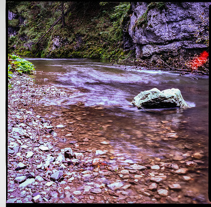 imperfect color film scan from old analog camera with dust and scratches. with black frame from negative. countryside lake or river view