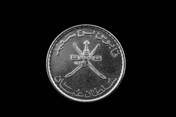 A macro image of a 50 baisa coin from Oman isolated on black